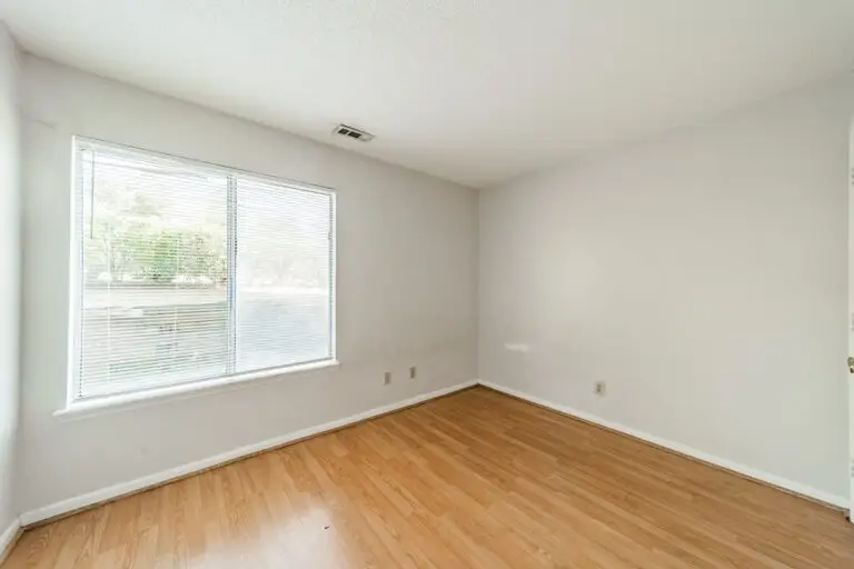 Bright, empty private room with wood floors ready for fall move-in at University Terrace, near UNC Charlotte